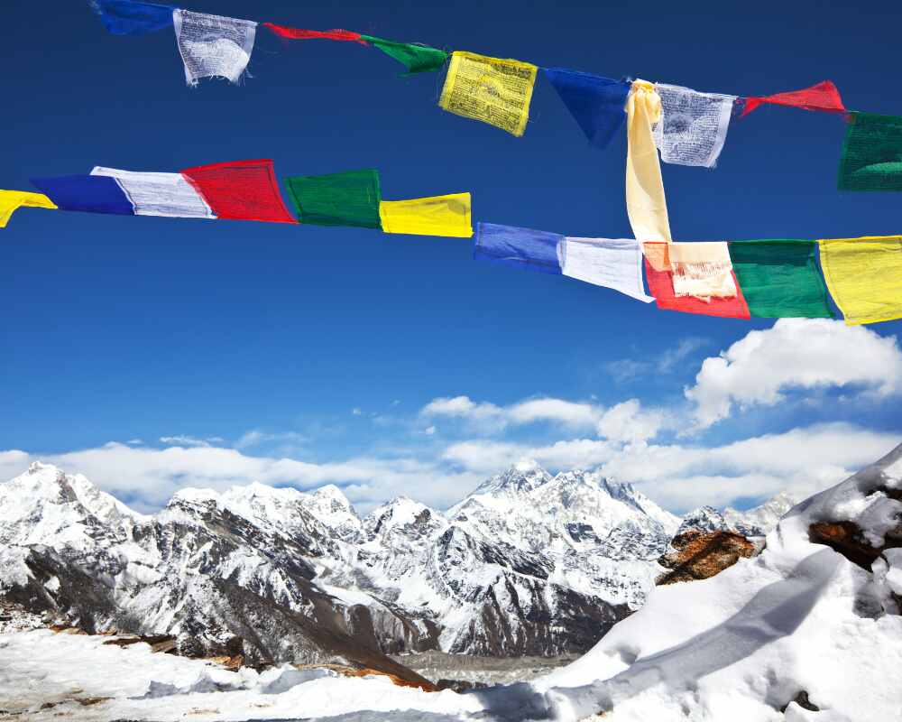 snow-dusted trail or frosty prayer flags with clear blue sky